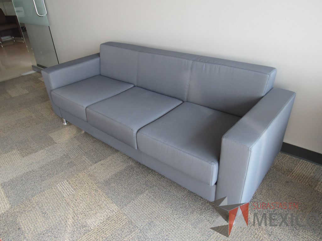 Lote 026 - Sillón de 3 plazas con 4 patas metálicas, asiento y respaldo en tela color gris.