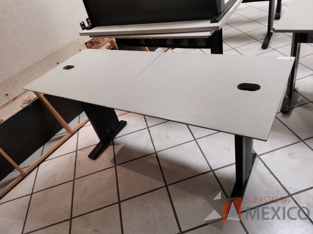 Lote 052 - Escritorio en dos secciones con estructura metálica negra, cubierta color gris y orificios recubiertos para cables