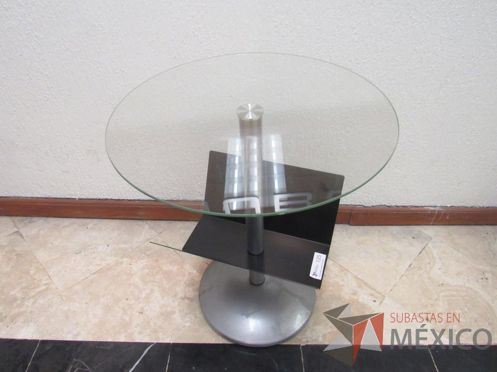 Lote 139 - Mesa de apoyo con cubierta circular de vidrio, base metálica y revistero