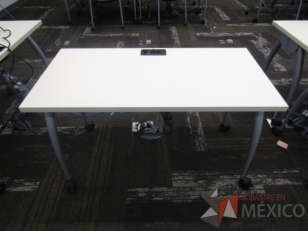 Lote 009 - 25 Mesas de trabajo con 4 patas metálicas con ruedas, cubierta color blanco y con orificios para cable.