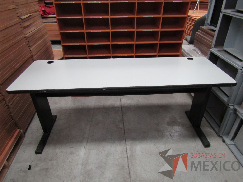 Lote 063 - Mesa de trabajo con estructura metálica, cubierta color gris y orificios para cables
