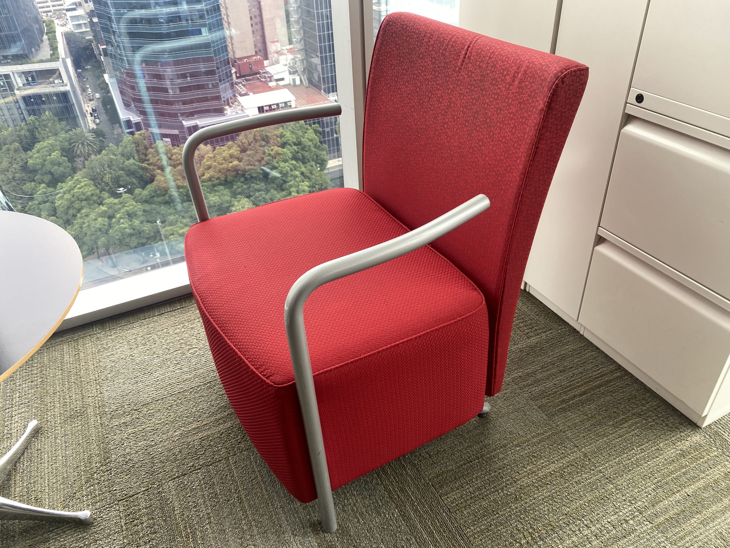 Lote 008 - Sillón de 1 plaza con descansa brazos metálicos, asiento y respaldo en tela color rojo.
