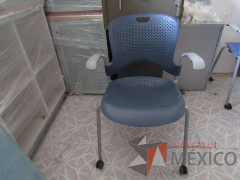 Lote 014 - Silla de visita Herman Miller, asiento y respaldo en plástico color azul fuerte, patas metálicas con ruedas