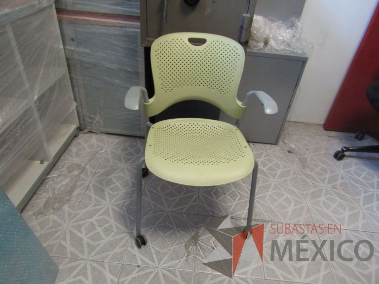 Lote 076 - Silla de visita Herman Miller, asiento y respaldo en plástico color verde, patas metálicas con ruedas