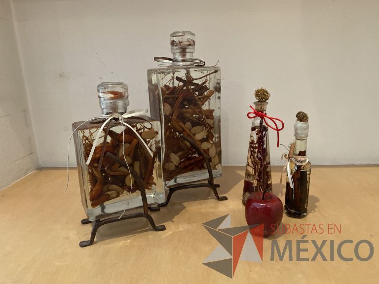 Lote 016 - Set con: 4 botellas de vidrio con decoración en el interior y 1 manzana artificial