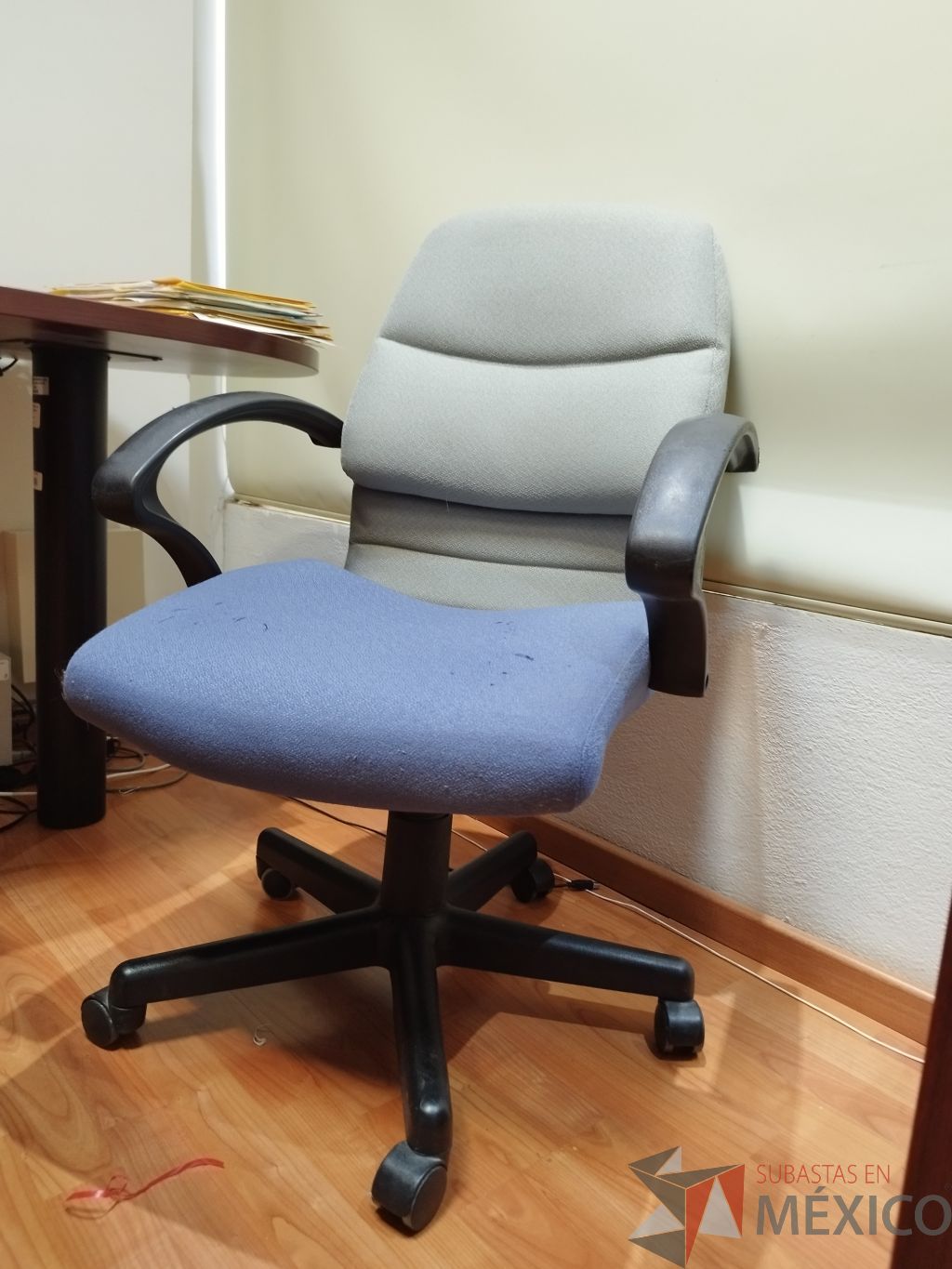 Lote 015 - Silla operativa, con descansabrazos, ruedas, asiento en tela color azul y respaldo en tela color gris