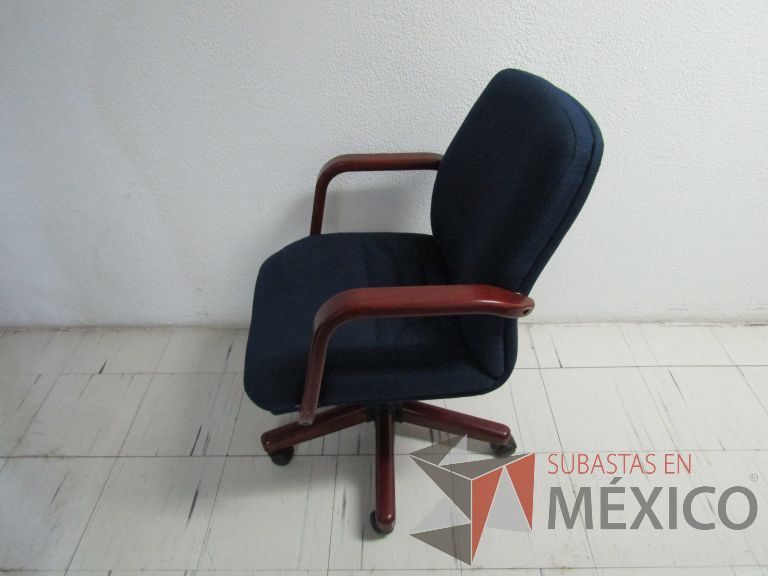 Lote 133 - Silla ejecutiva con ruedas, descansabrazos de madera, asiento y respaldo en tela color azul - Imagen 8
