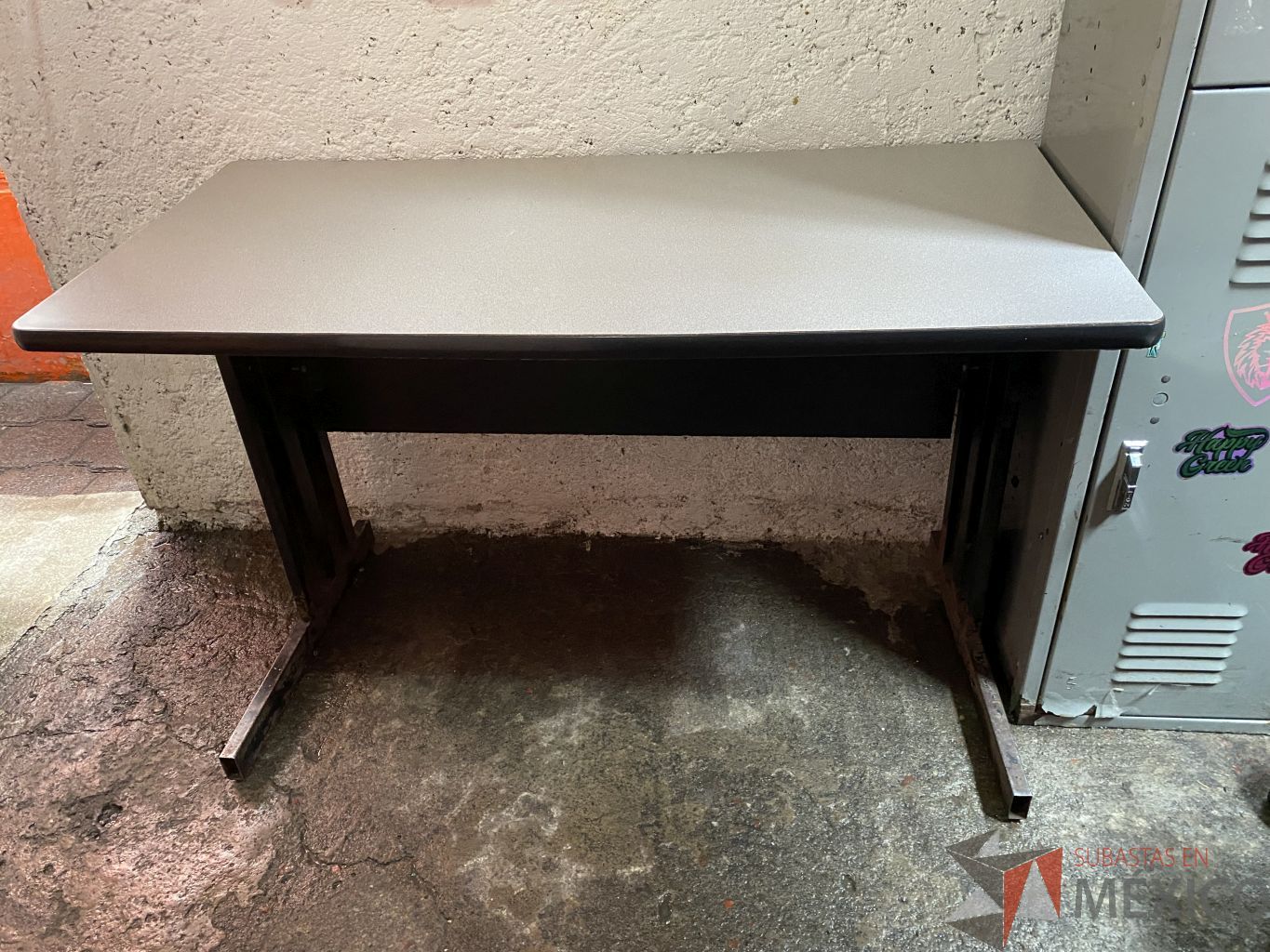 Lote 031 - Mesa de trabajo con base metálica y cubierta en color gris