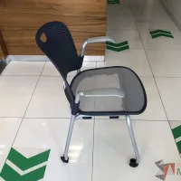 Lote 091 - Silla de visita con ruedas, descansabrazos, asiento en malla y respaldo en plástico color azul - Imagen 2