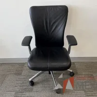 Lote 151 - Silla operativa con ruedas, descansabrazos, asiento y respaldo en piel color negro