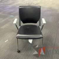 Lote 004 - Silla de visita con ruedas, descansabrazos, asiento y respaldo color negro