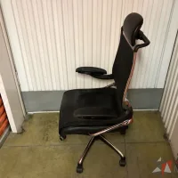 Lote 018 - Silla operativa con ruedas, descansabrazos, cabecera, asiento en piel y respaldo en malla color negro - Imagen 4