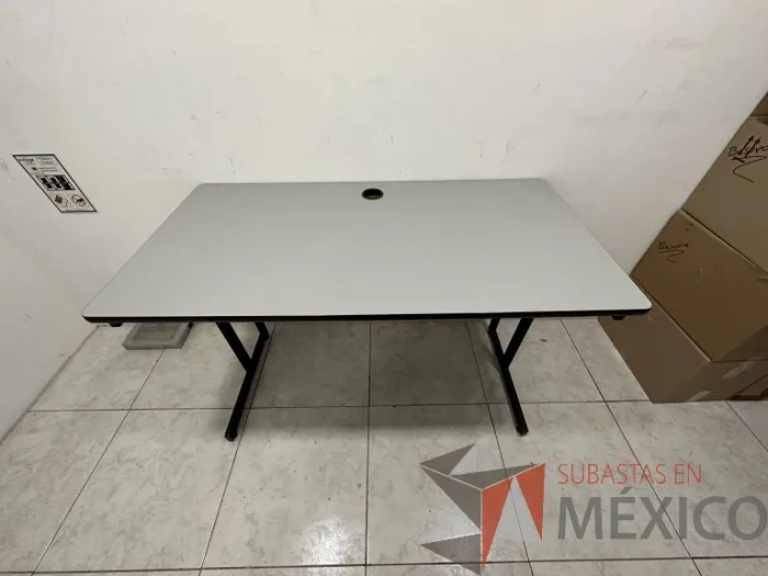 Lote 004 - Escritorio con base metálica, cubierta color gris y orificio para cables