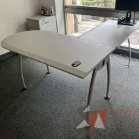 Lote 020 - Escritorio en escuadra de costado izquierdo con base metálica, orificio para cables y cubierta color gris