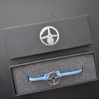 Lote 037 - Volante. Brazalete , figura de volante en metal, nuevo