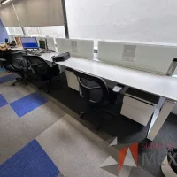 Lote 003 - Estación de trabajo lineal para 5 personas, con divisiones de vidrio, orificios para conexiones, y 5 archiveros verticales de 2 cajones con ruedas