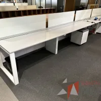 Lote 017 - Estación de trabajo lineal para 4 personas, con divisiones de vidrio, orificios para conexiones, y 4 archiveros verticales de 2 cajones con ruedas 600 cm x 72 cm x 112 cm
