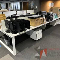 Lote 018 - Estación de trabajo para 8 personas, con divisiones de vidrio, orificios para conexiones, y 8 archiveros verticales de 2 cajones con ruedas. - Imagen 4