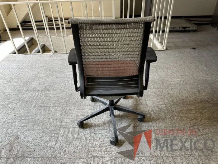 Lote 002 - 6 Sillas operativas con ruedas, descansabrazos, asiento en tela color rojo y respaldo en malla color beige - Imagen 7